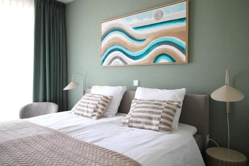 ベルゲン・アーン・ゼーにあるBest Western Beach Hotel Bergen aan Zeeのベッドと壁に絵が飾られた寝室