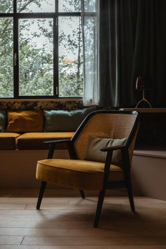 a chair in a room with a couch and a window at Domaine Saint Clair - Le Donjon in Étretat