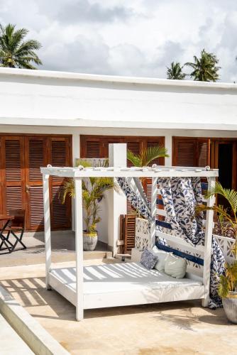 a bed on the deck of a house at ZAN Orient Beach Hotel in Bwejuu