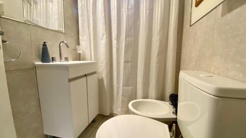 un bagno bianco con un water e un lavandino di Aloha Teo - Departamento por Día en Trelew, espacioso y cerca de todo! a Trelew
