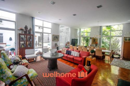 a living room with red couches and a table at Casa em Guaramiranga com Piscina Coberta in Guaramiranga