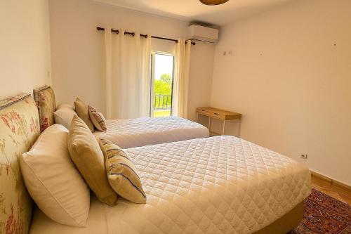 a bedroom with two beds and a window at Golden Triangle Retreat Near Quinta do Lago in Almancil
