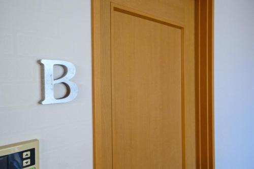 a letter b on a wall next to a door at space AJITO in Kofu