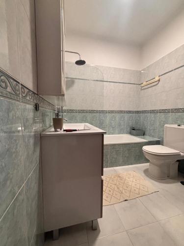 a bathroom with a sink and a toilet and a tub at Golden Triangle Retreat Near Quinta do Lago in Almancil