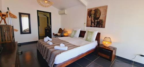 a bedroom with a bed with towels on it at Villa Rêve Austral in Grands Bois
