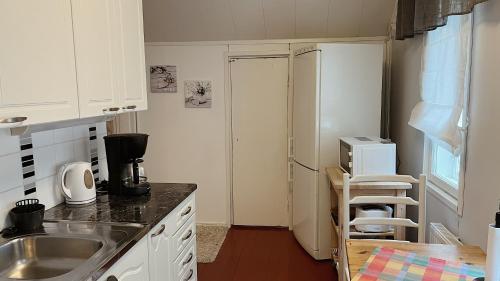 a small kitchen with a sink and a refrigerator at Kodit Tuulikinkatu in Mikkeli