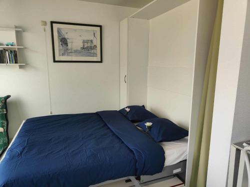 a bedroom with a blue comforter on a bed at Sand Rose Studio in Koksijde