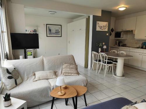 a living room with a couch and a table at Sand Rose Studio in Koksijde