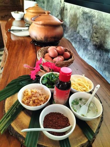 a table with bowls of food on a table at Sum sumbuy Homestay ซำ ซำบาย โฮมสเตย์ in Ban Bo