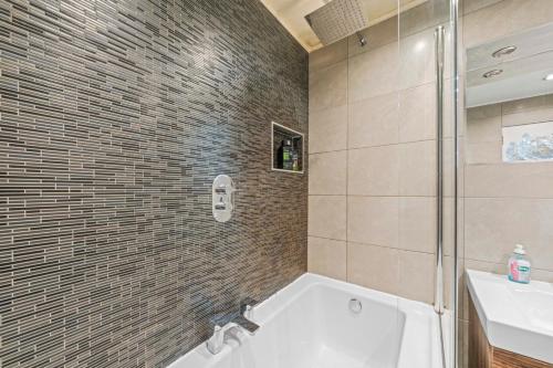 a bathroom with a tub and a shower and a sink at Unique Victorian Home in Glasgow in Glasgow