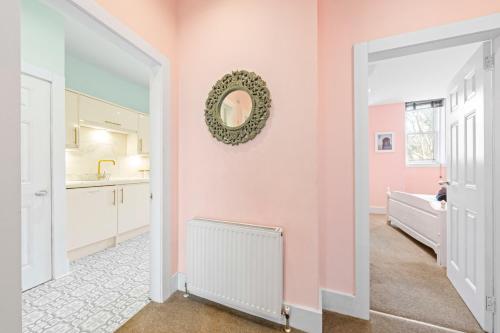 a kitchen with pink walls and a white door at Unique Victorian Home in Glasgow in Glasgow