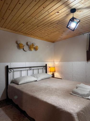 a bedroom with a large bed with a wooden ceiling at Sykia Home in Sikia