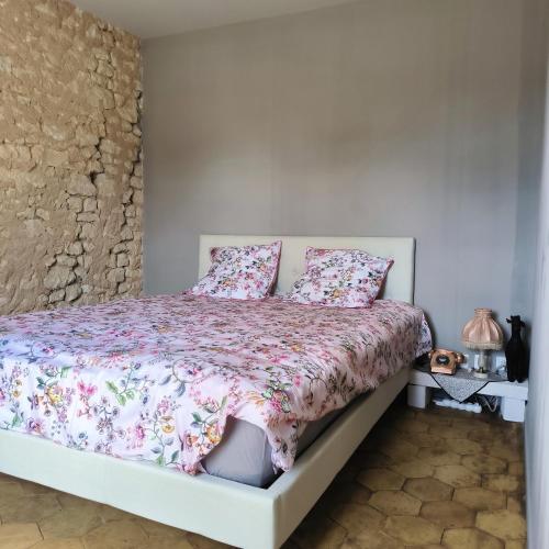 a bedroom with a white bed with pink pillows at Gîte de l'épure avec patio in Rémalard en Perche