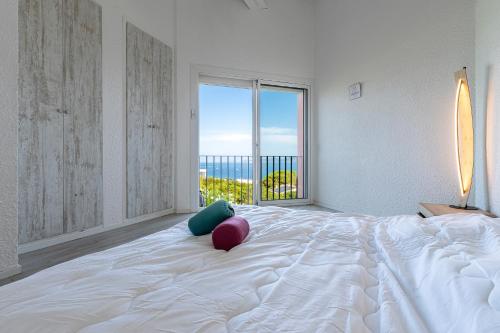 une chambre blanche avec un grand lit avec une grande fenêtre dans l'établissement Canelli - Magnifique Vue Mer, à Pietrosella