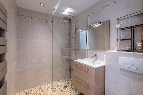 une salle de bain avec un lavabo et une douche en verre dans l'établissement Canelli - Magnifique Vue Mer, à Pietrosella