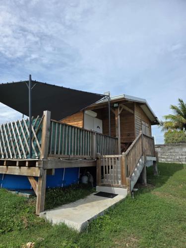 a wooden house with a black roof and a porch at Haven Paradise in Sainte-Anne