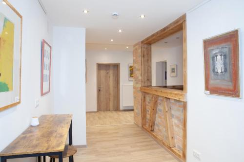 a living room with a wooden table and a wall at Dorfwirt Pfronten in Pfronten
