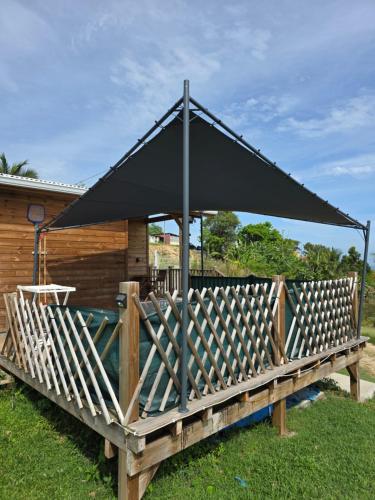 a black canopy on top of a wooden deck at Haven Paradise in Sainte-Anne