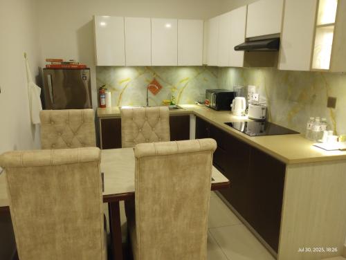 a kitchen with a table with chairs and a refrigerator at OCEAN BREEZE - WAVES LUXURY CONDO in Negombo