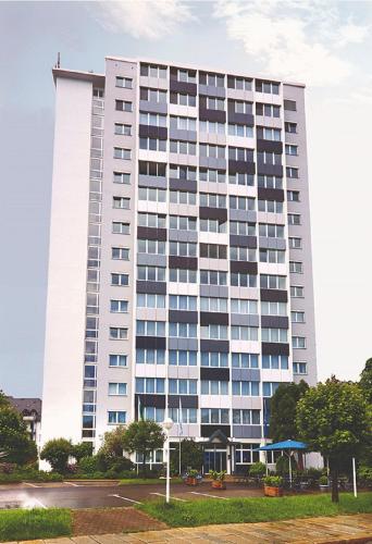 a tall white building with a lot of windows at Seaside Residenz Hotel Chemnitz in Chemnitz
