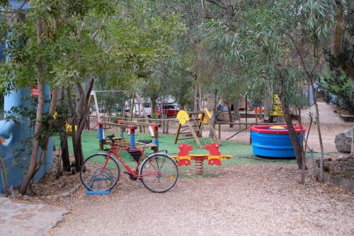 a bike parked in front of a playground at Happy Camp mobile homes in Selema Camping in Santa Lucia