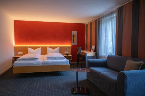 a hotel room with a bed and a couch at Schäfle Feldkirch-Altenstadt in Feldkirch