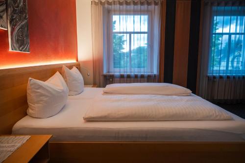 two beds in a room with two windows at Schäfle Feldkirch-Altenstadt in Feldkirch