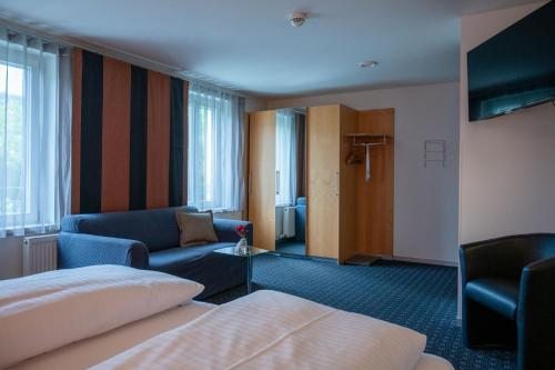 a hotel room with a bed and a couch at Schäfle Feldkirch-Altenstadt in Feldkirch