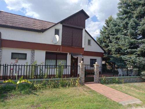 una casa con una puerta y una valla en Derű Apartman, en Mezőkövesd