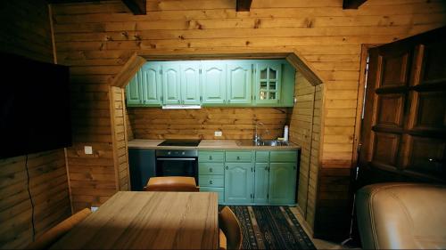 a small kitchen with green cabinets and a table at Villa n'Mal in Orllan