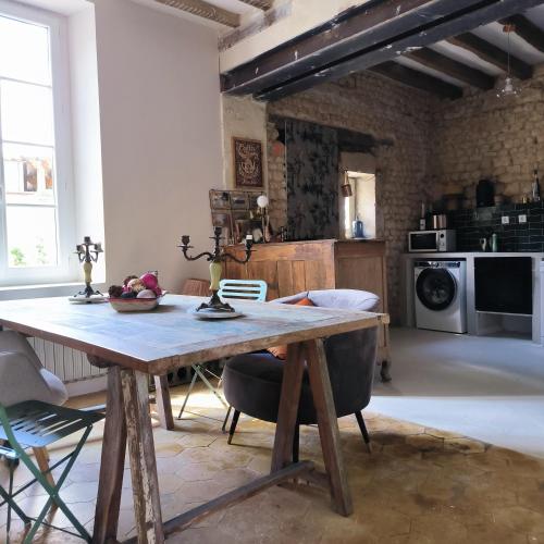 a kitchen with a wooden table in a room at Gîte de l'épure avec patio in Rémalard en Perche