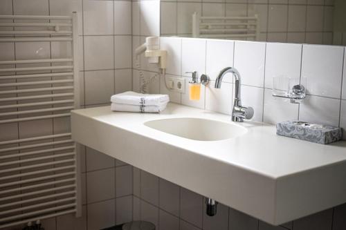 a bathroom with a white sink and a mirror at Schäfle Feldkirch-Altenstadt in Feldkirch