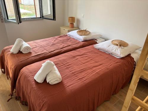 two beds in a room with towels on them at Idéal pour un séjour à Bordeaux in Blanquefort