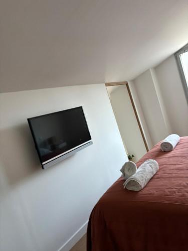 a bedroom with a bed with a tv on the wall at Idéal pour un séjour à Bordeaux in Blanquefort