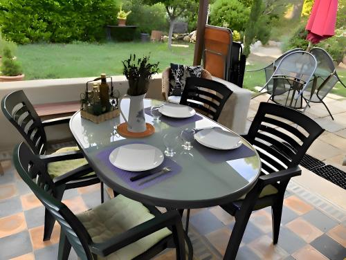 a table and chairs sitting on a patio at Oasi Des Mirabelles - Gîte in Mirabel-aux-Baronnies