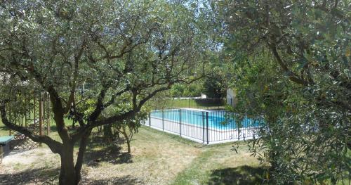 a fence around a swimming pool in a yard at Oasi Des Mirabelles - Gîte in Mirabel-aux-Baronnies