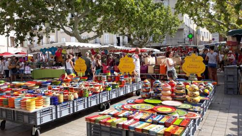 a market with several carts of food on a street at Oasi Des Mirabelles - Gîte in Mirabel-aux-Baronnies