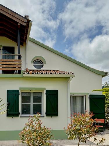 a white house with green shutters on it at Casa dos Netos - Garden & Lake III (Sete Cidades) in Sete Cidades