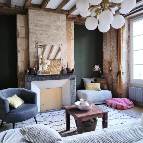 a living room with a couch and a fireplace at Gîte de l'épure avec patio in Rémalard en Perche
