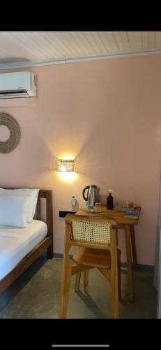 a room with a table and a bed and a table with a telephone at Sky Breeze in Unawatuna