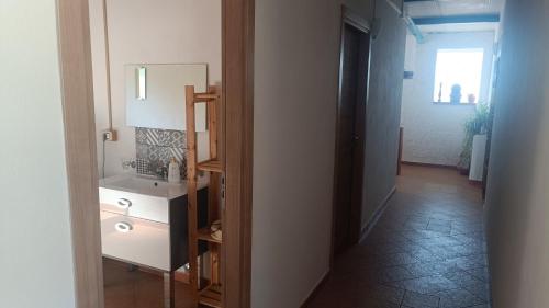 a bathroom with a sink and a mirror and a hallway at LaGreka2025 in San Pantaleone