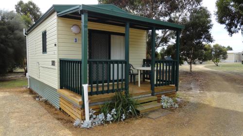 a tiny house with a porch and a table at Kangaroo Island Cabins in Kingscote