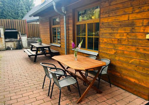 a wooden table and chairs on a patio at Apartmán na sjezdovce in Sedloňov