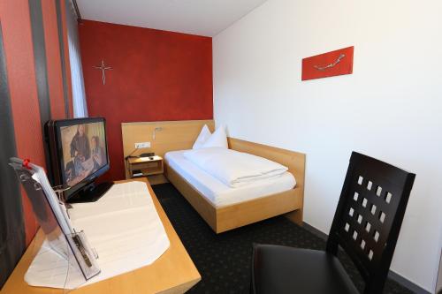 a small room with a bed and a desk with a computer at Schäfle Feldkirch-Altenstadt in Feldkirch