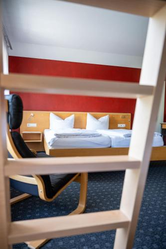 a bedroom with a bed and a chair in a room at Schäfle Feldkirch-Altenstadt in Feldkirch