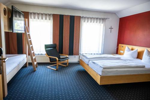 a hotel room with two beds and a chair at Schäfle Feldkirch-Altenstadt in Feldkirch