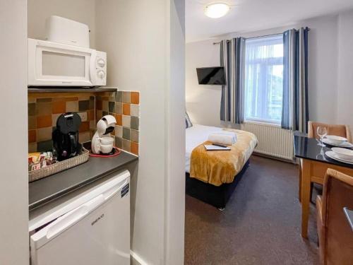 a small room with a bed and a microwave at Pier View Skegness in Skegness