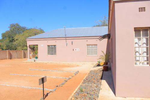 a building with a bunch of rocks in front of it at MB guesthouse in Kasane
