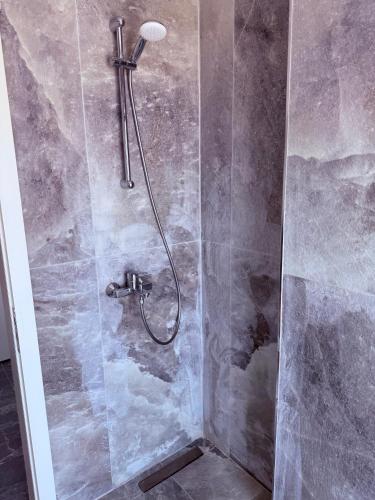 a shower with a shower head in a bathroom at Rana Hedhun Seaside 1 in Lezhë