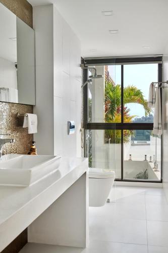 a bathroom with two sinks and a toilet and a window at Icon Villa Samui in Nathon Bay